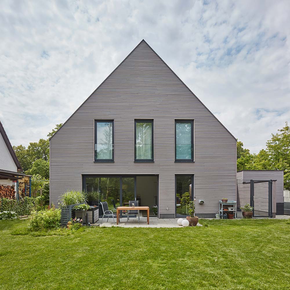 Gartenansicht auf ein Haus in Holzbauweise mit Fassade aus horizontaler Lärchenholzschalung