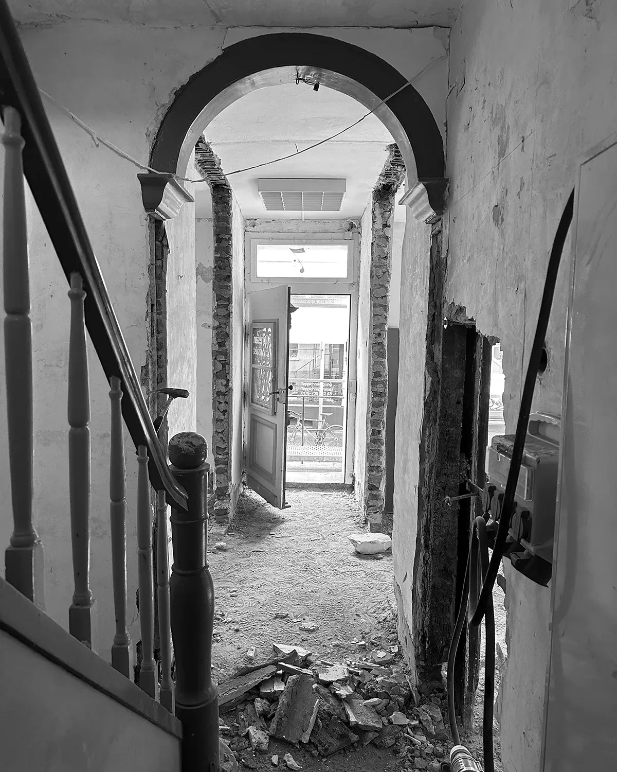 Innenansicht des Stadthauses während der Sanierung mit freigelegtem Mauerwerk, historischem Rundbogen und Blick zum Eingang.